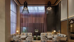 A modern lobby with a seating area, large windows, and a café sign. - The Fern Mumbai, Goregaon, Series by Marriott (Mumbai)