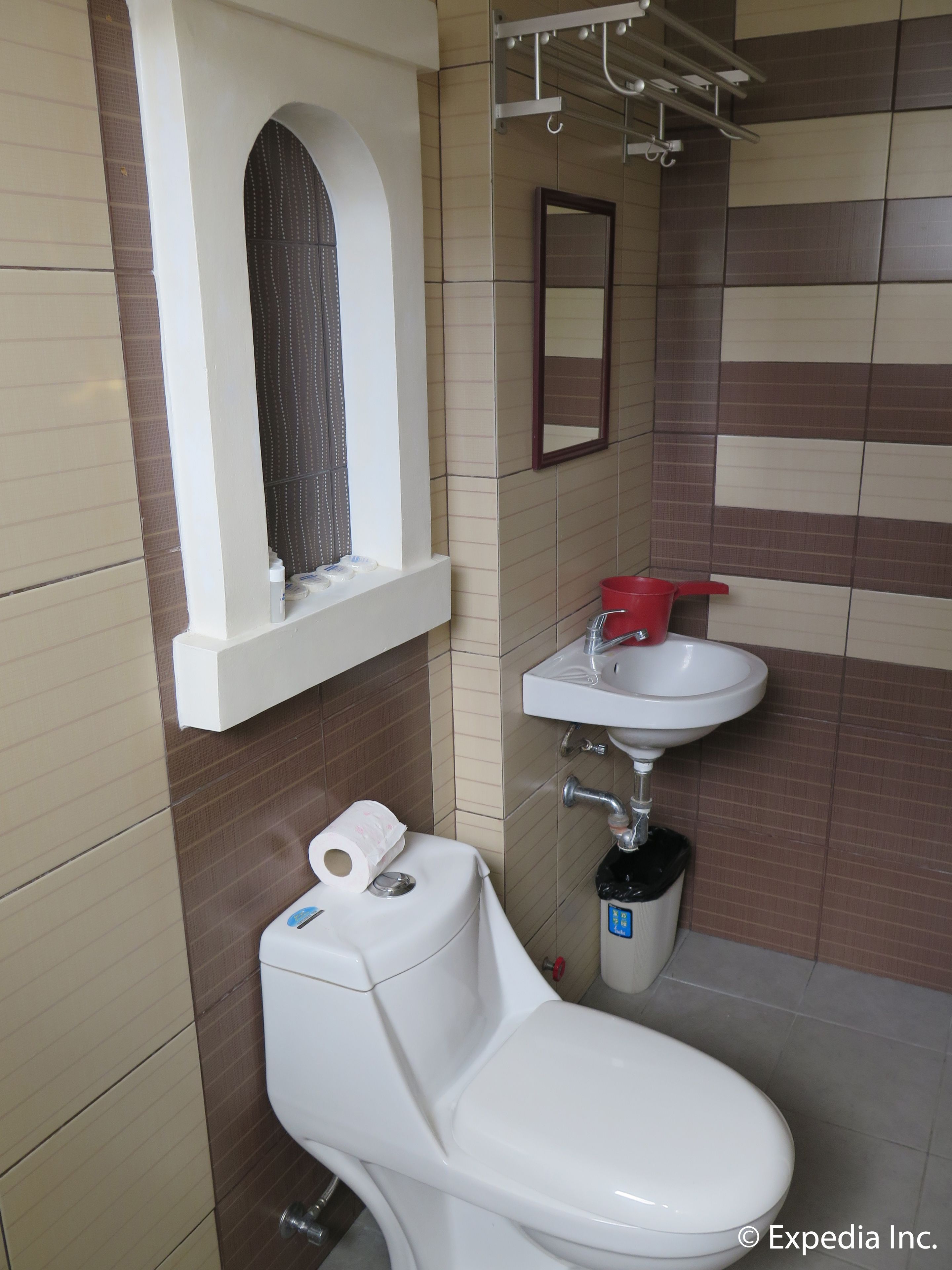 Une salle de bain avec des toilettes, un lavabo et une fenêtre.