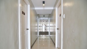 A corridor with doors labeled 107 and 108, leading to a bright room with a large window. - The Windy Ridge Inn (Tagaytay)