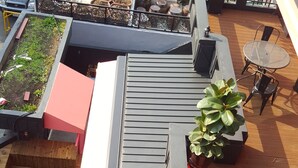 A rooftop terrace with multiple seating areas, planters, and a small table. - Amazon Guesthouse - Hostel (Seoul)