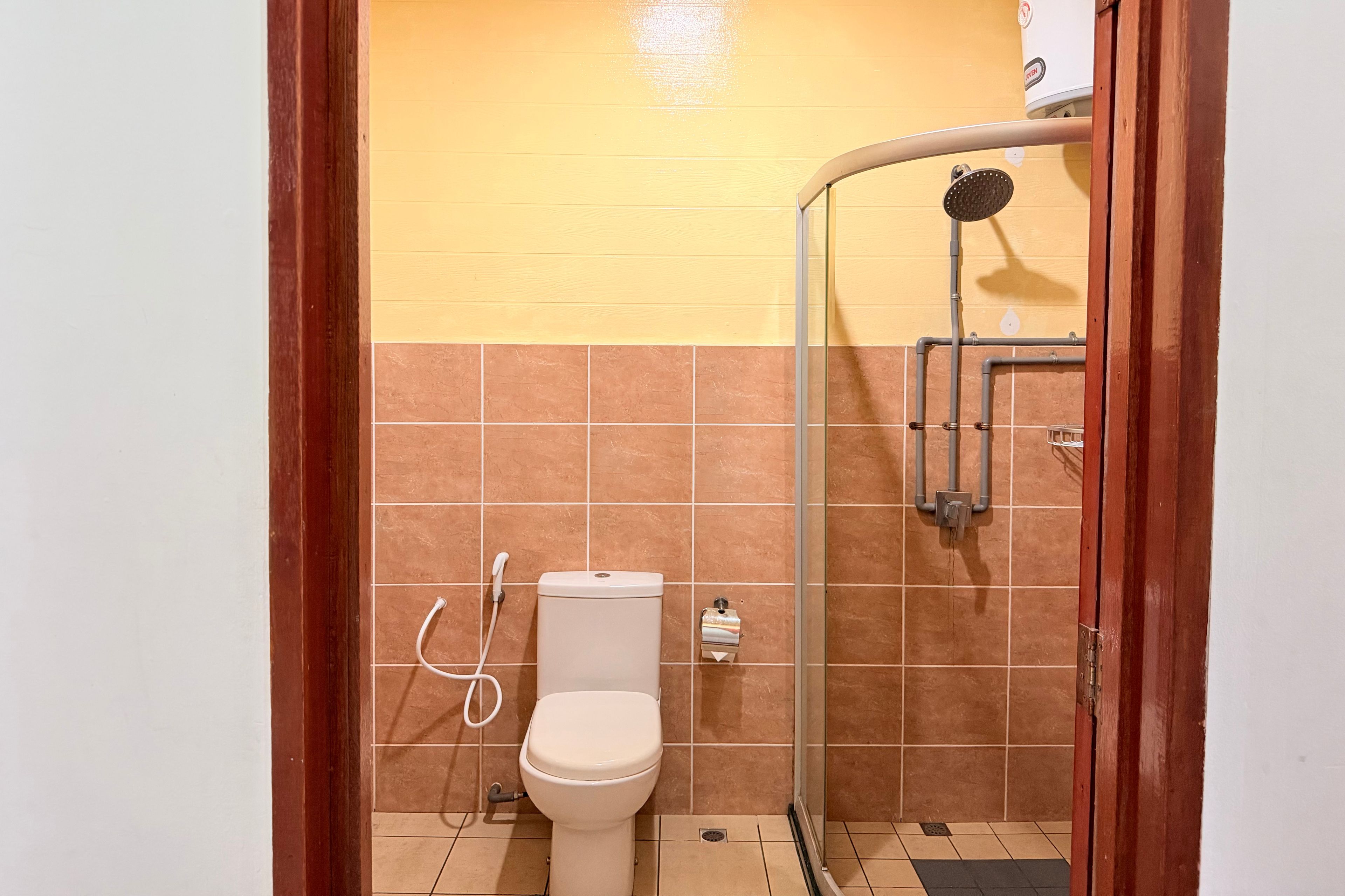 A bathroom with a toilet, a shower, and a towel rack.