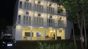 A multi-story hotel with balconies, air conditioning units, and a reception area. - Heaven By O (Unawatuna)