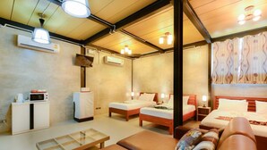 A hotel room with two beds, a sofa, a small table, and a microwave.
