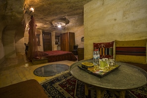 Una habitación acogedora con una mesa redonda, una cama y una alfombra pequeña.