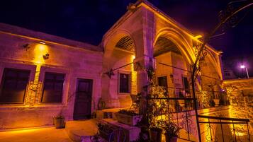 A historic building with arched windows and a stone facade, illuminated by warm lighting.