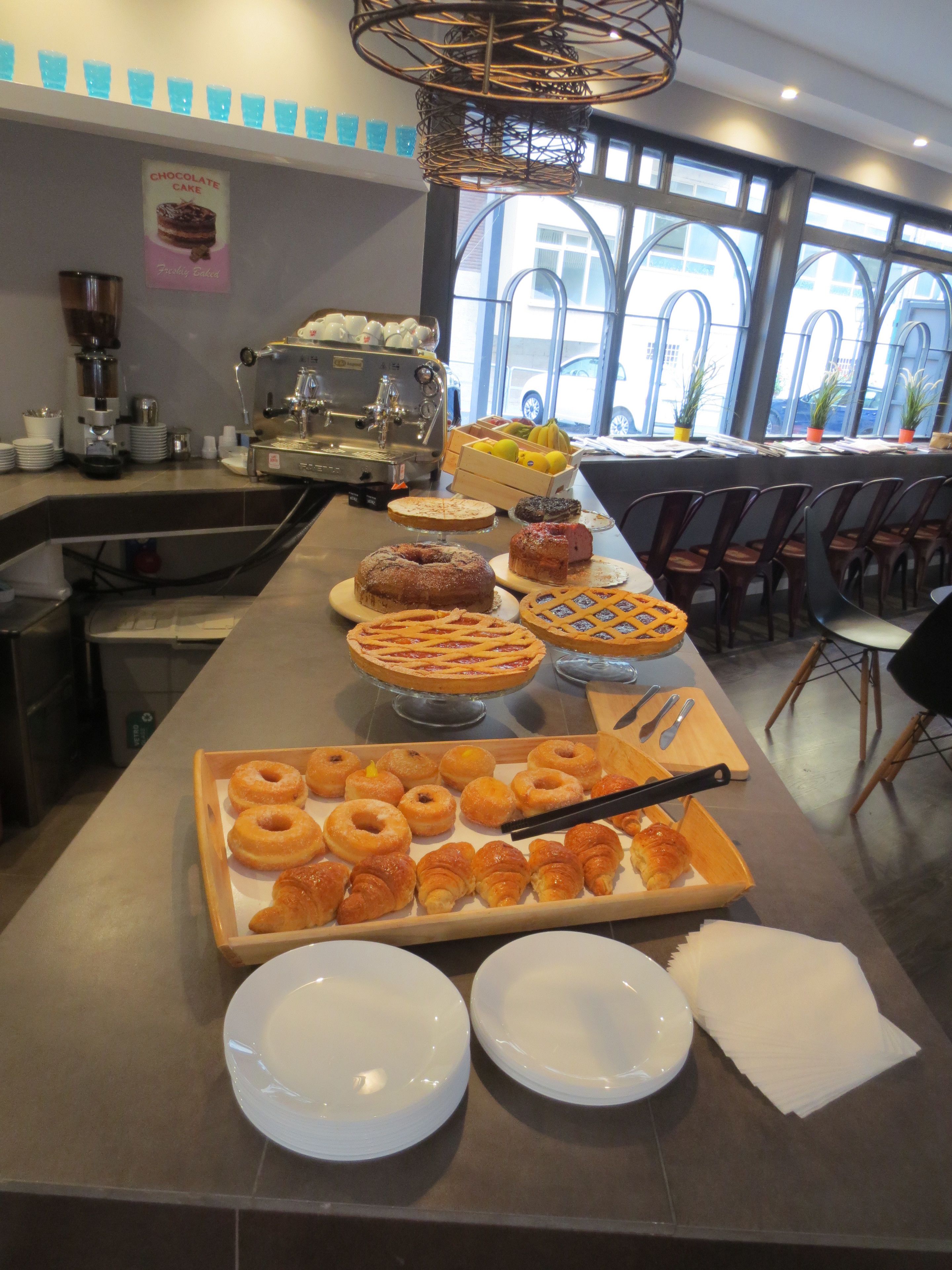 A buffet with various pastries and a coffee machine.