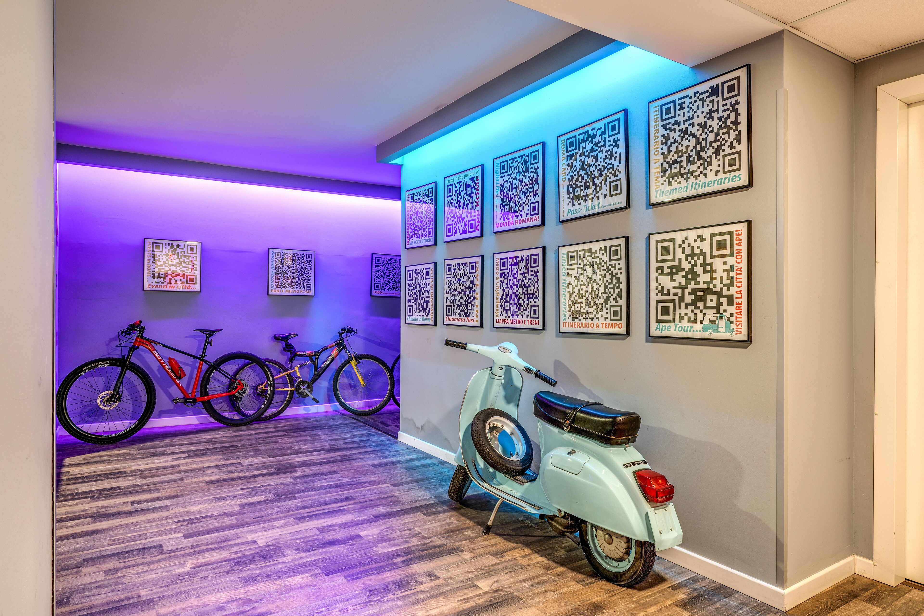 A hallway with bicycles and a scooter, walls with QR codes, and purple lighting.