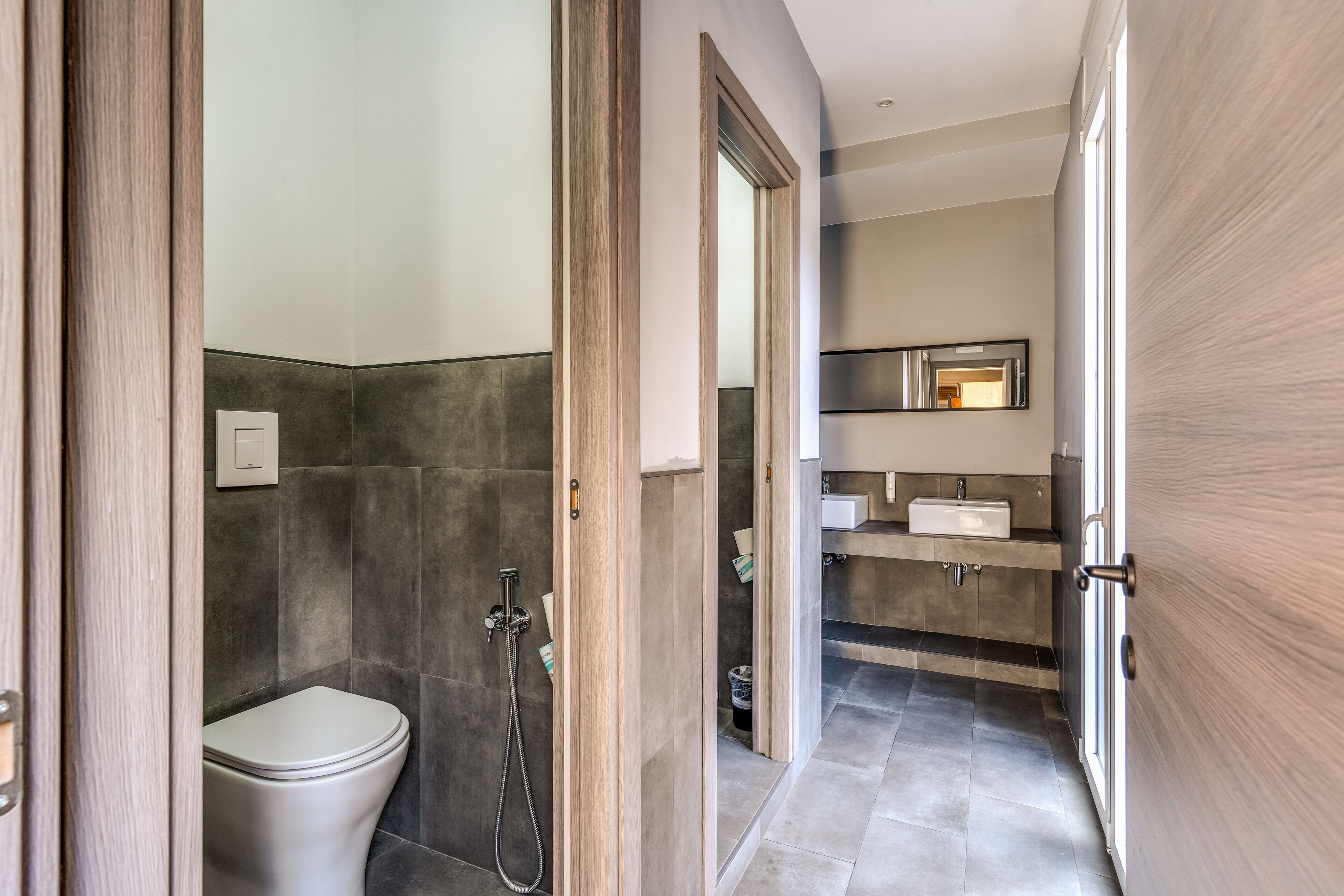 A modern bathroom with a toilet, shower, and vanity.