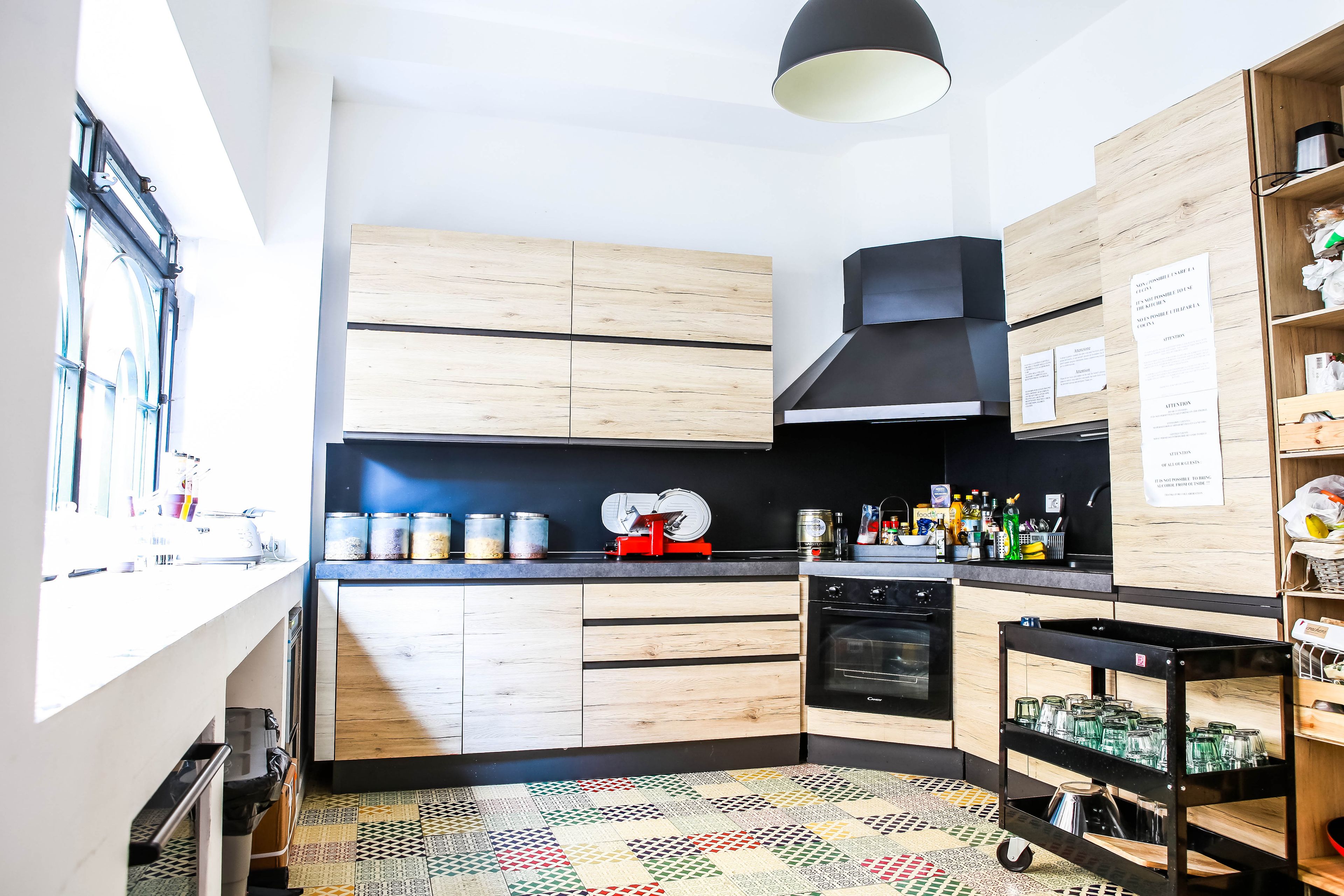 Una cocina moderna con armarios de madera, una campana extractora negra y un piso estampado.
