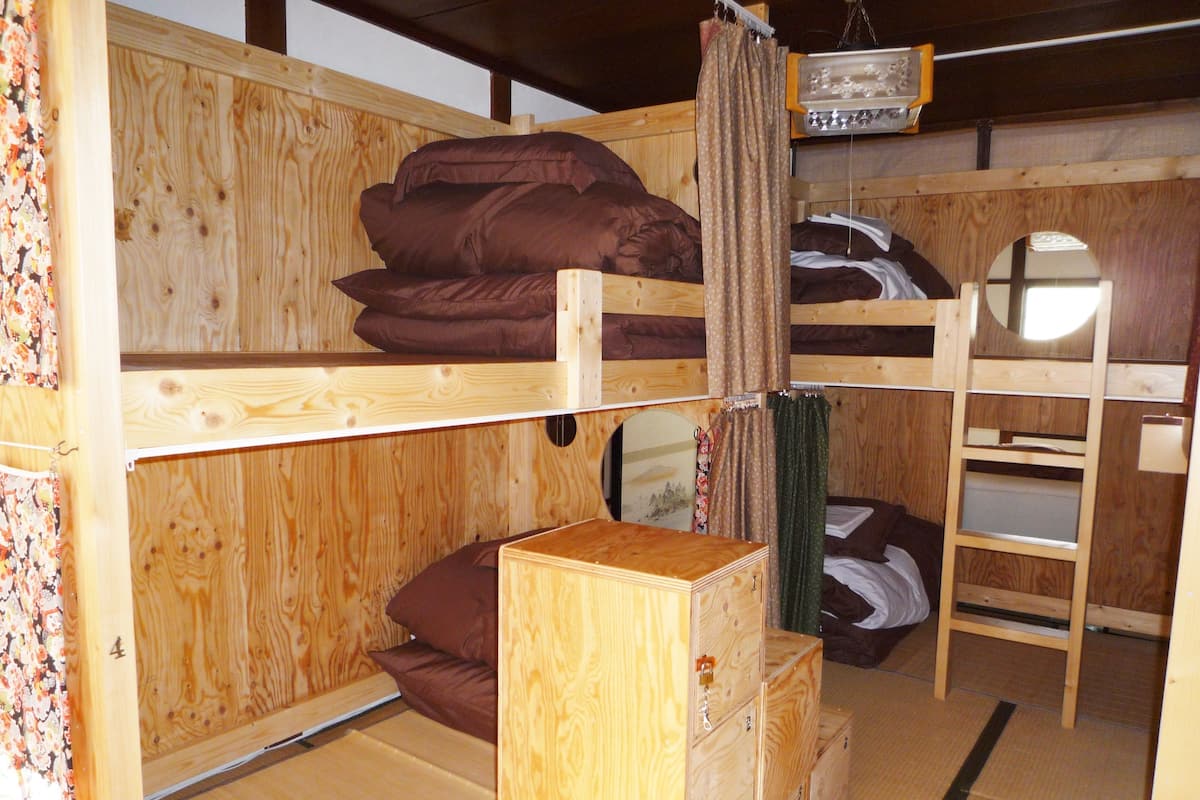 A wooden bunk bed room with a dresser and a mirror.