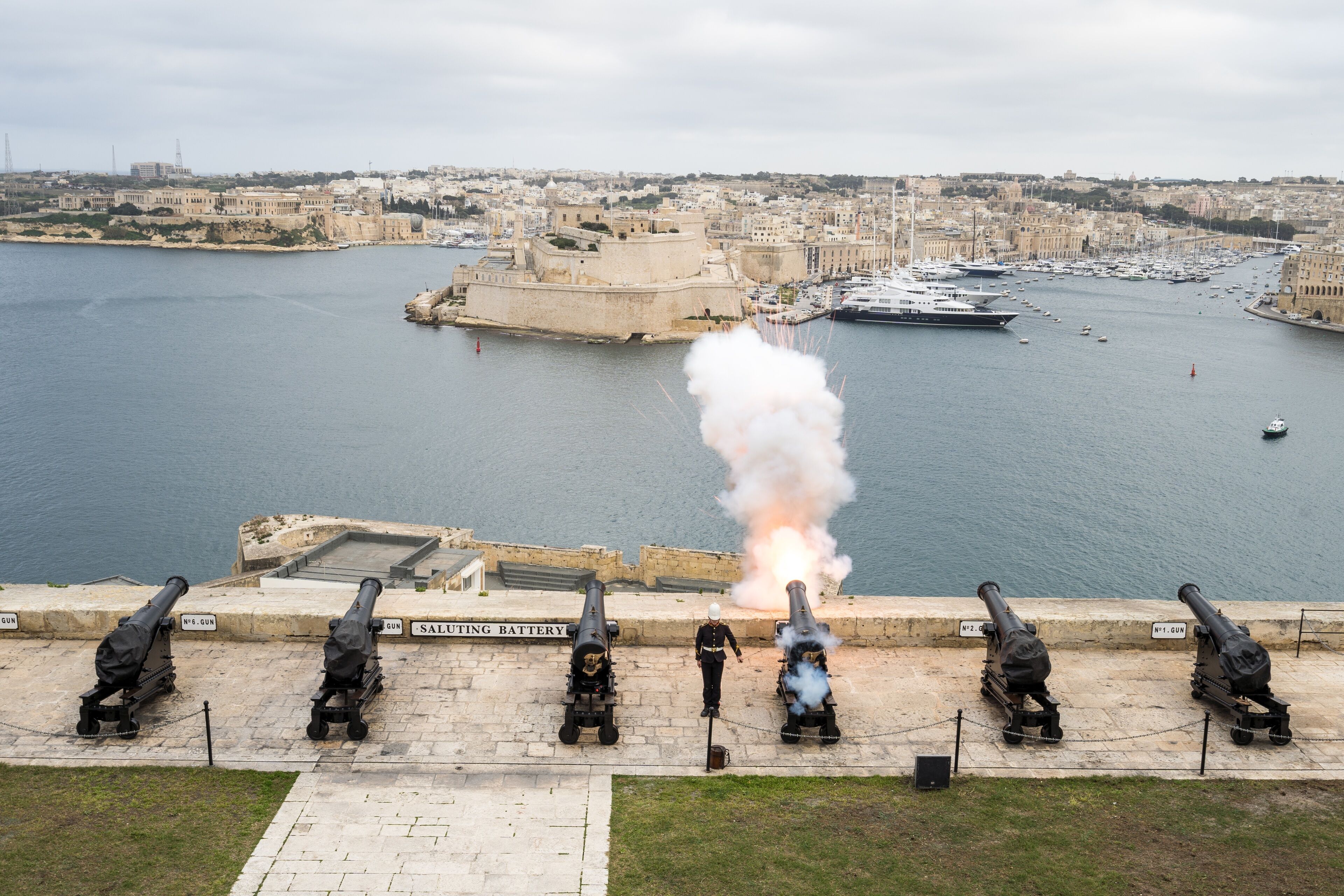 Un paysage urbain côtier, avec des fortifications historiques et un port.