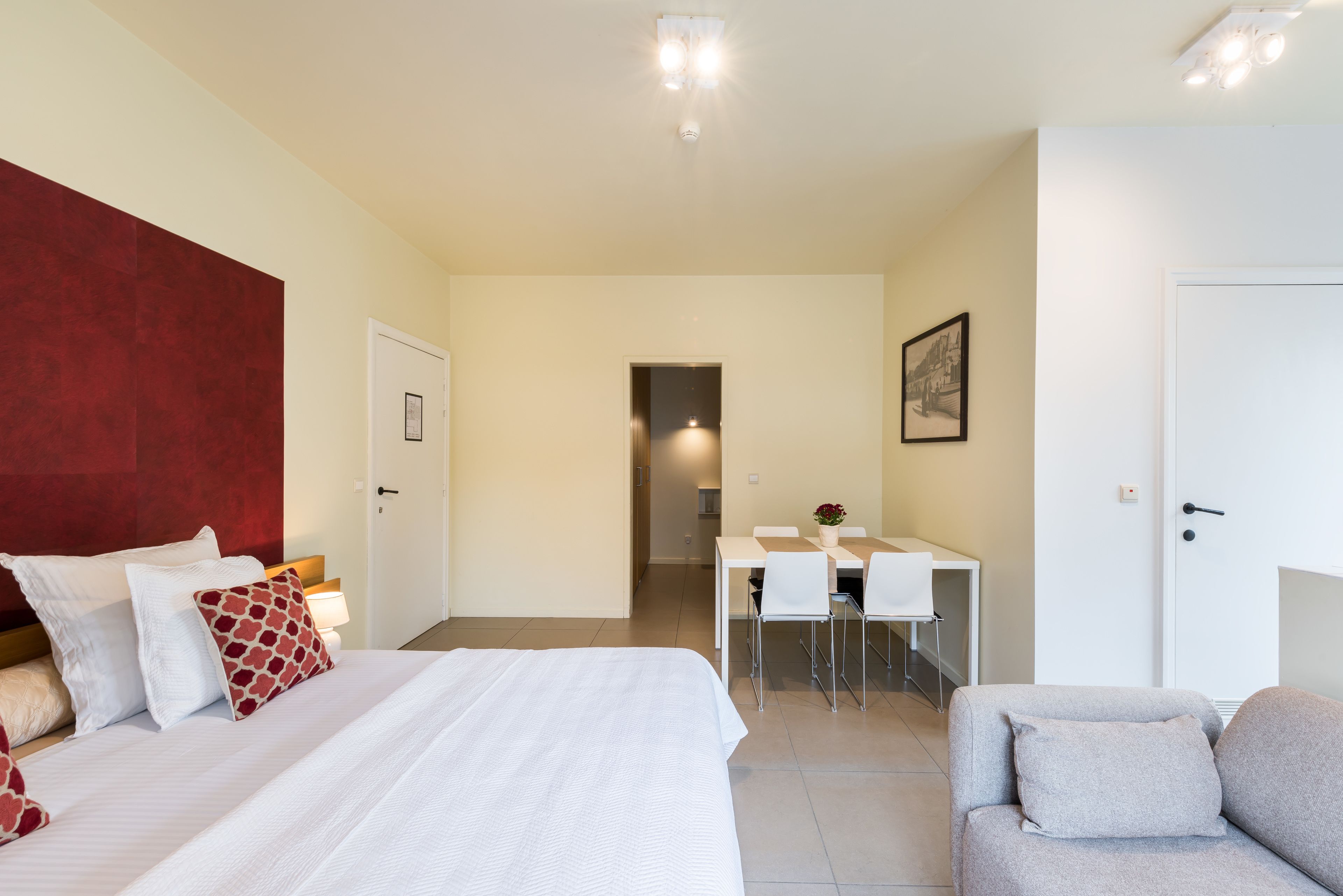 Et hotelværelse med seng, skrivebord, stol og sofa.