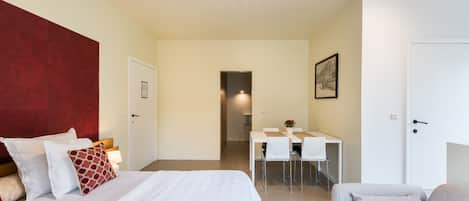 Et hotelværelse med seng, skrivebord, stol og sofa.