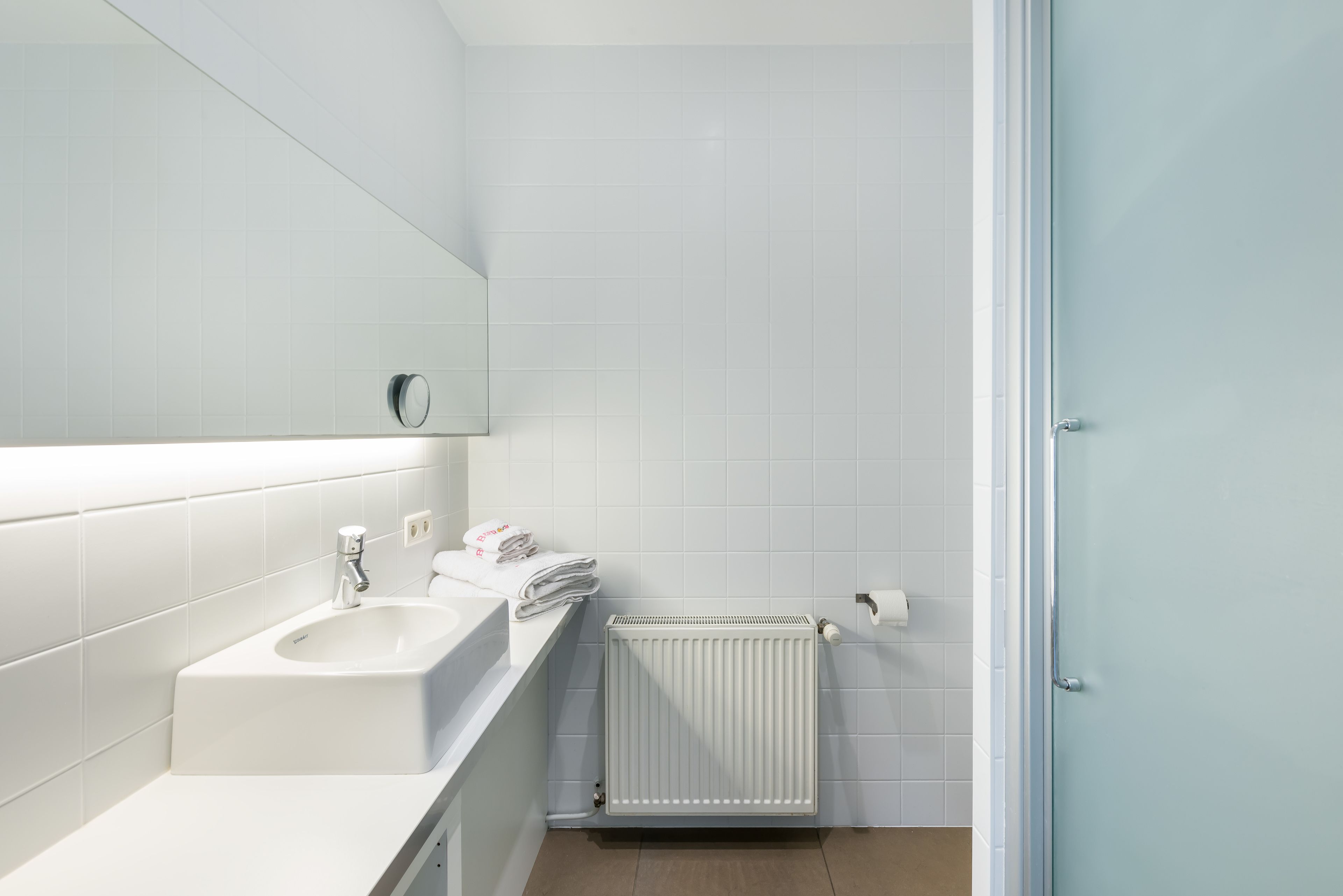 Une salle de bain moderne avec un lavabo, un miroir et des toilettes.