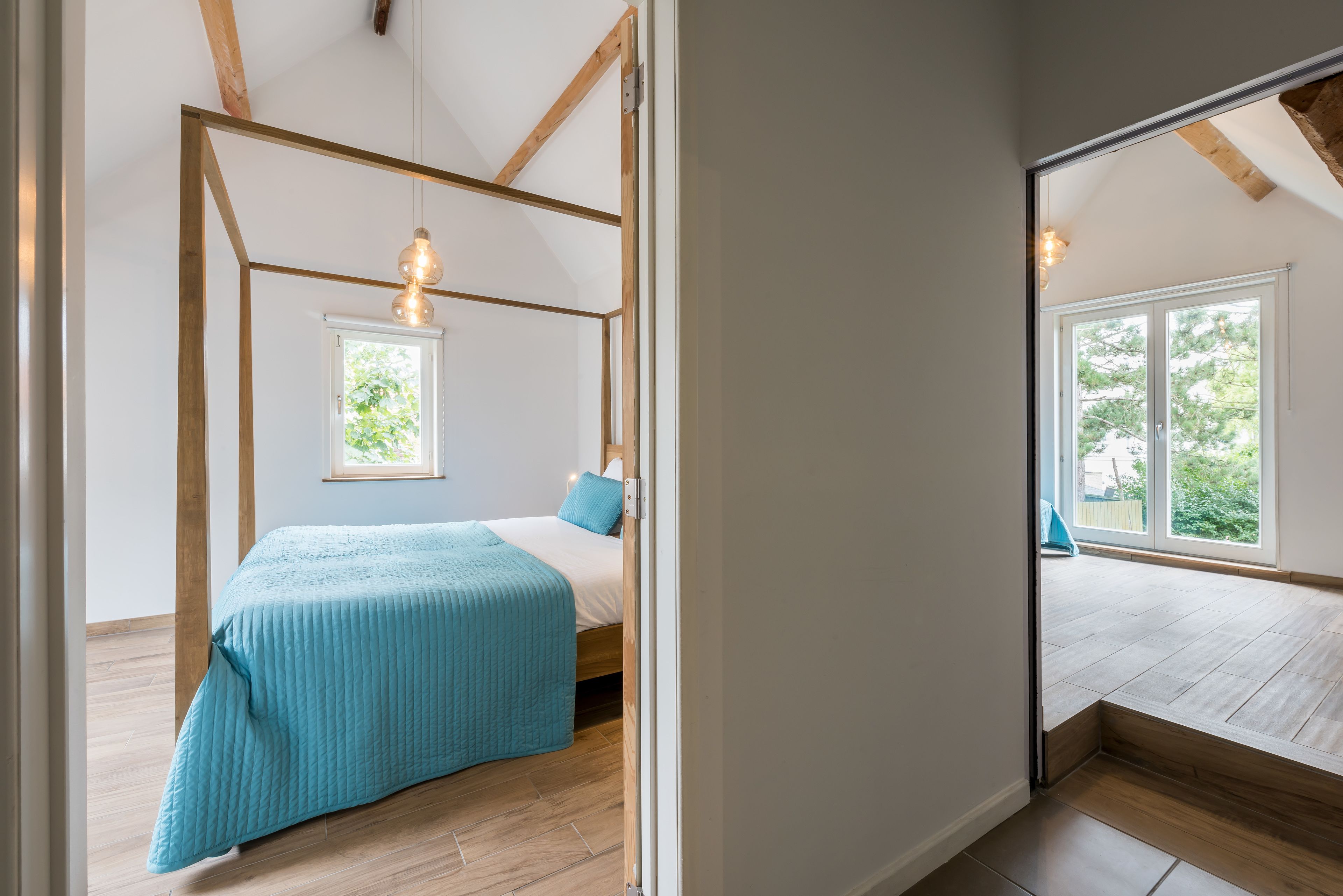 Een slaapkamer met een bed, een raam en uitzicht op de omgeving.