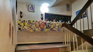 Una escalera con un colorido suelo de estampado geométrico y barandilla de madera.