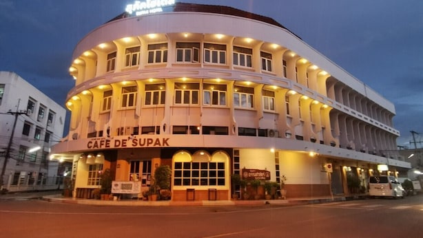 Un edificio de varios pisos con fachada curva, que dice "Café de Supak".
