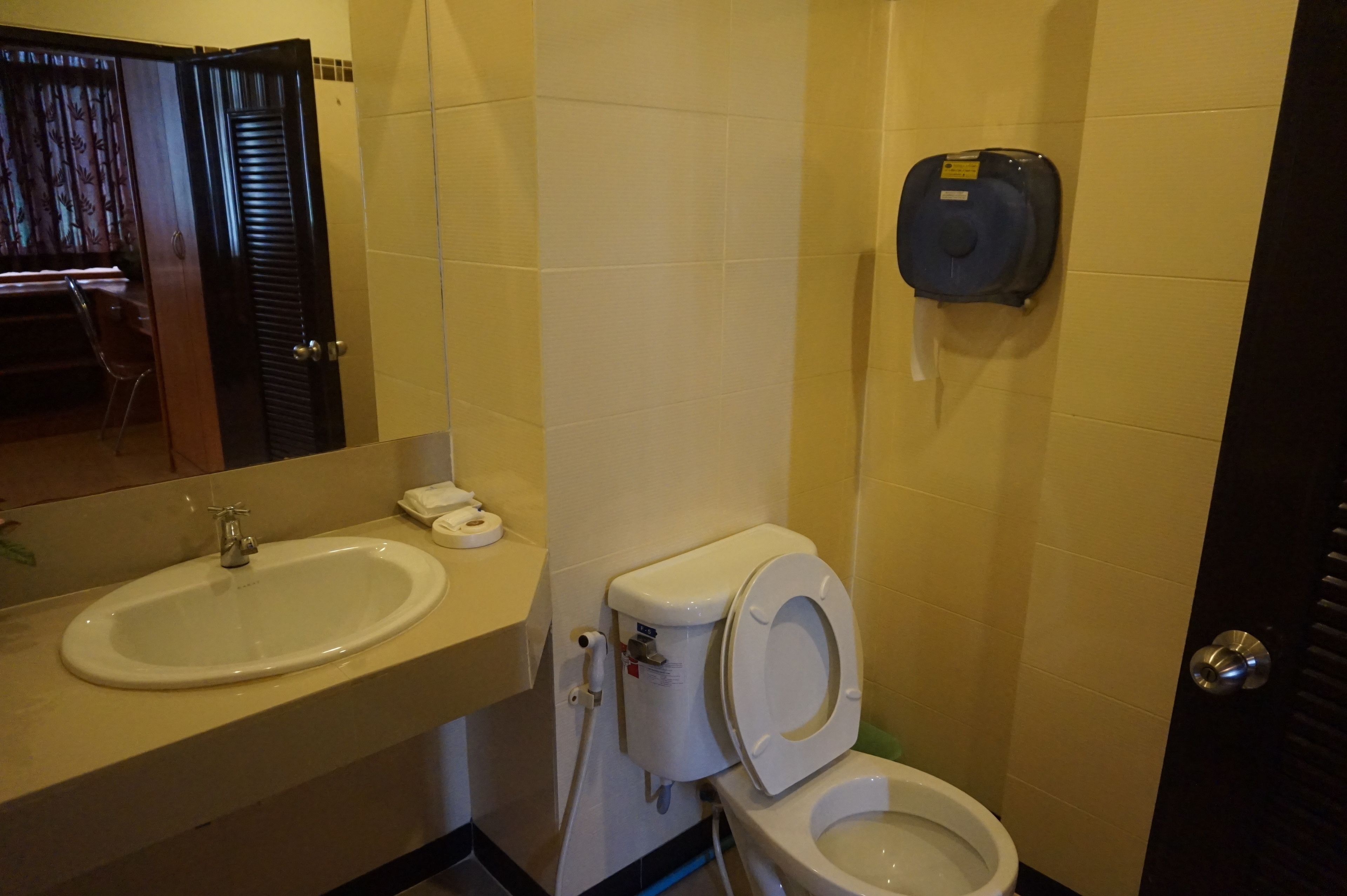 Ein Badezimmer mit Waschbecken, Toilette und Handtrockner.