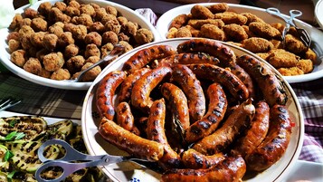 Variedad de salchichas a la parrilla y otros platos sobre una mesa.