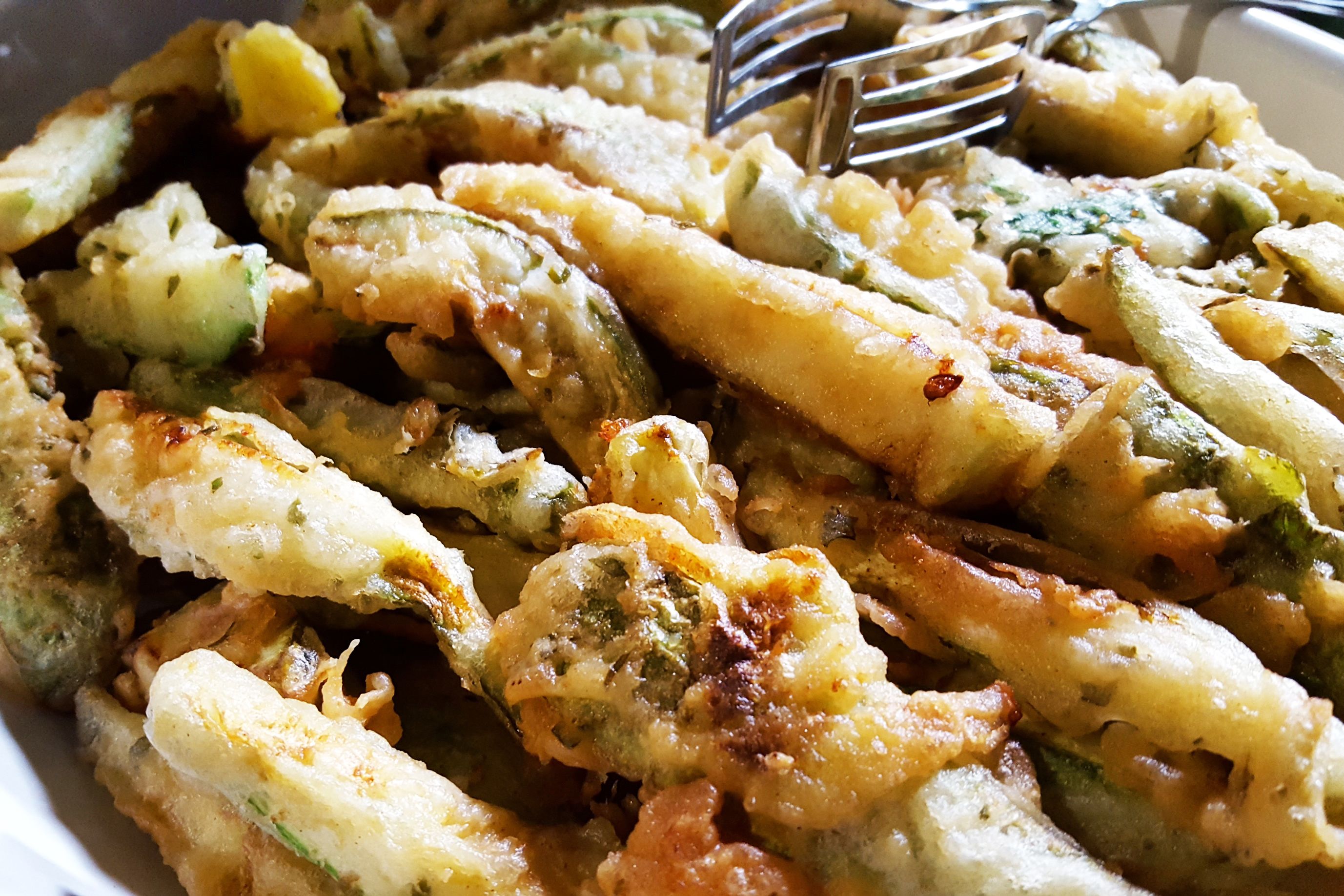 A close-up of a dish with various vegetables and a fork.
