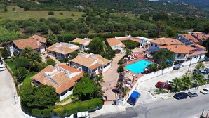 Zona residencial con casas, piscina y carretera.