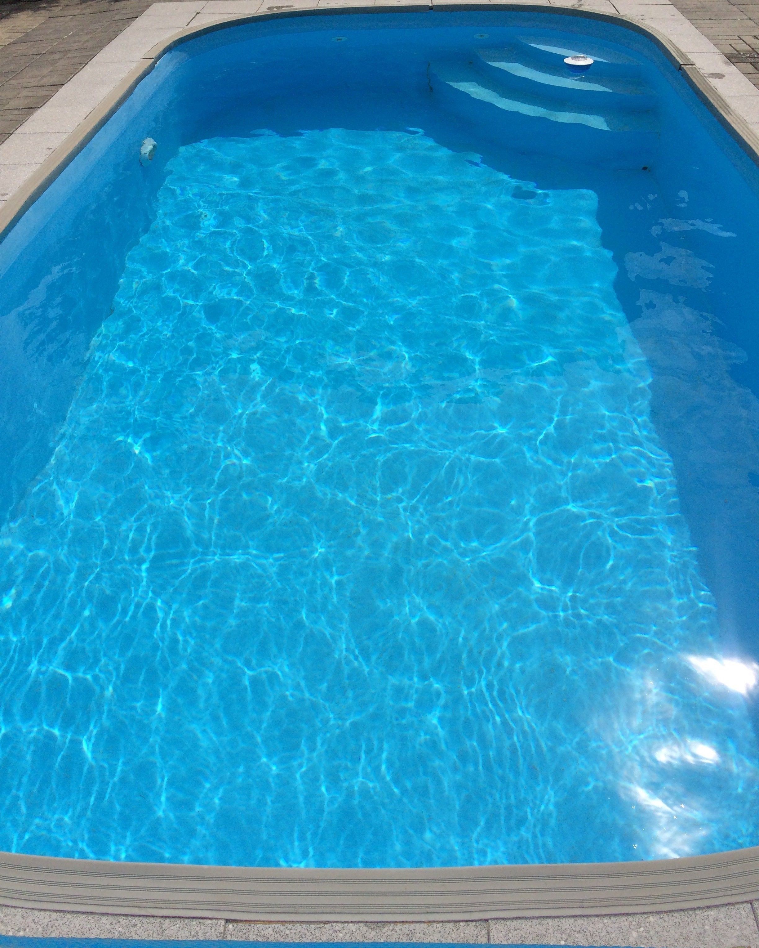Ein rechteckiger Pool mit klarem, blauem Wasser.