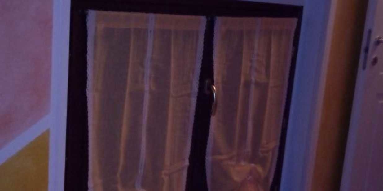 A room with a door featuring a wooden frame and a curtain.