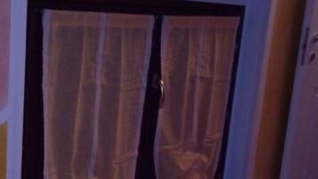 A room with a door featuring a wooden frame and a curtain.