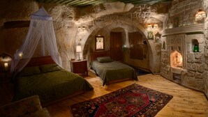 Un dormitorio rústico con dos camas, una chimenea de piedra y una cama con dosel.