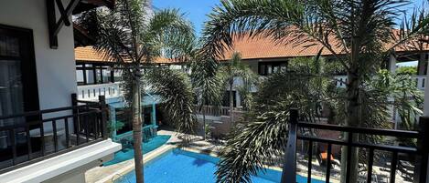 Een buitenzwembad, ligstoelen bij het zwembad