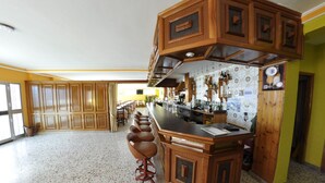 A spacious kitchen with a central island, wooden cabinets, and a tiled backsplash. - Hotel Galicia (Poio)