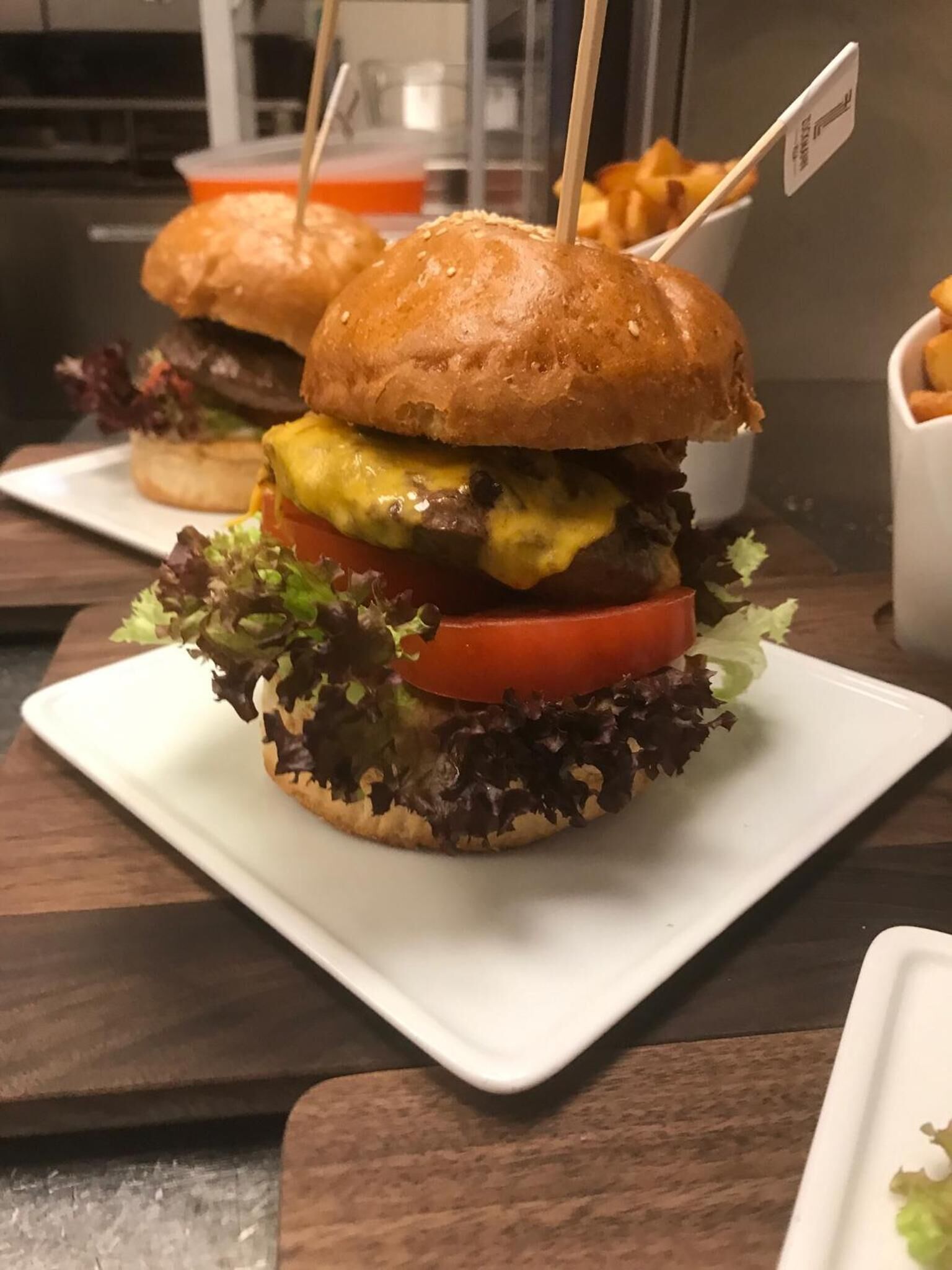 A sandwich with a toothpick on top, placed on a white plate.