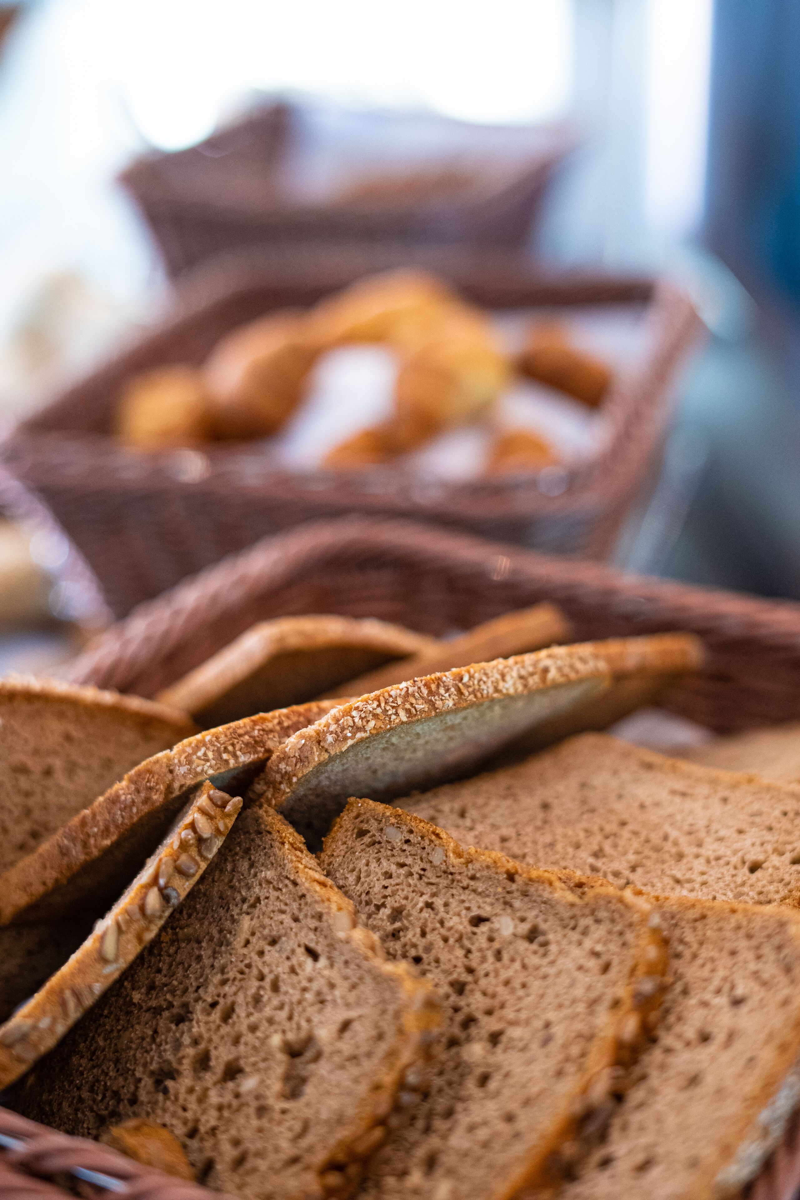 Detailaufnahme von Brot mit sichtbaren Samen und Getreide, anmutig in einem Korb angeordnet.