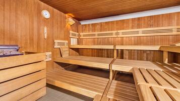 A sauna with wooden benches and a clock on the wall.