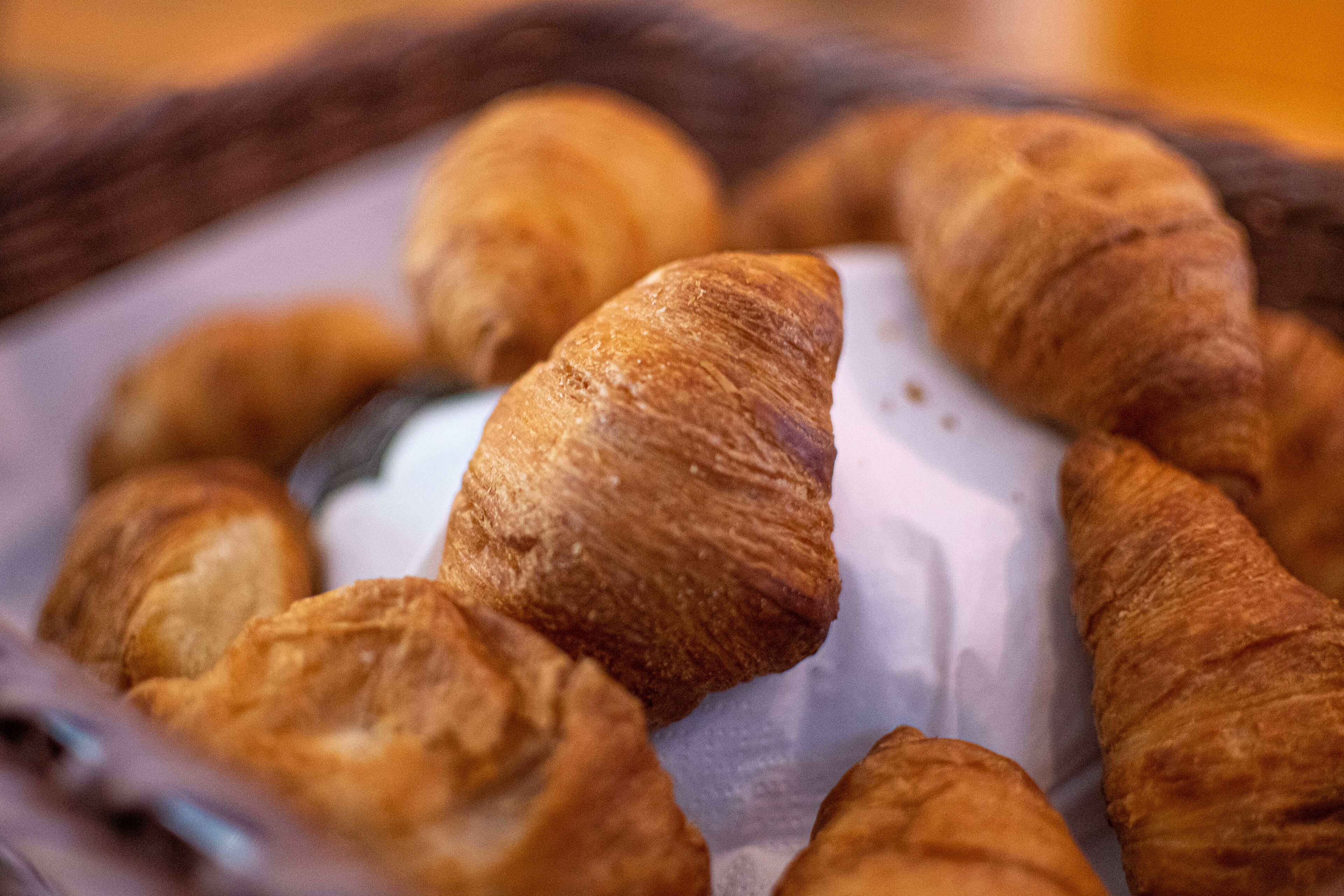 Un panier de croissants sur une feuille de papier blanche.