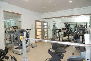Un gimnasio con equipo de ejercicio variado, incluyendo cintas de correr y máquinas de pesas.