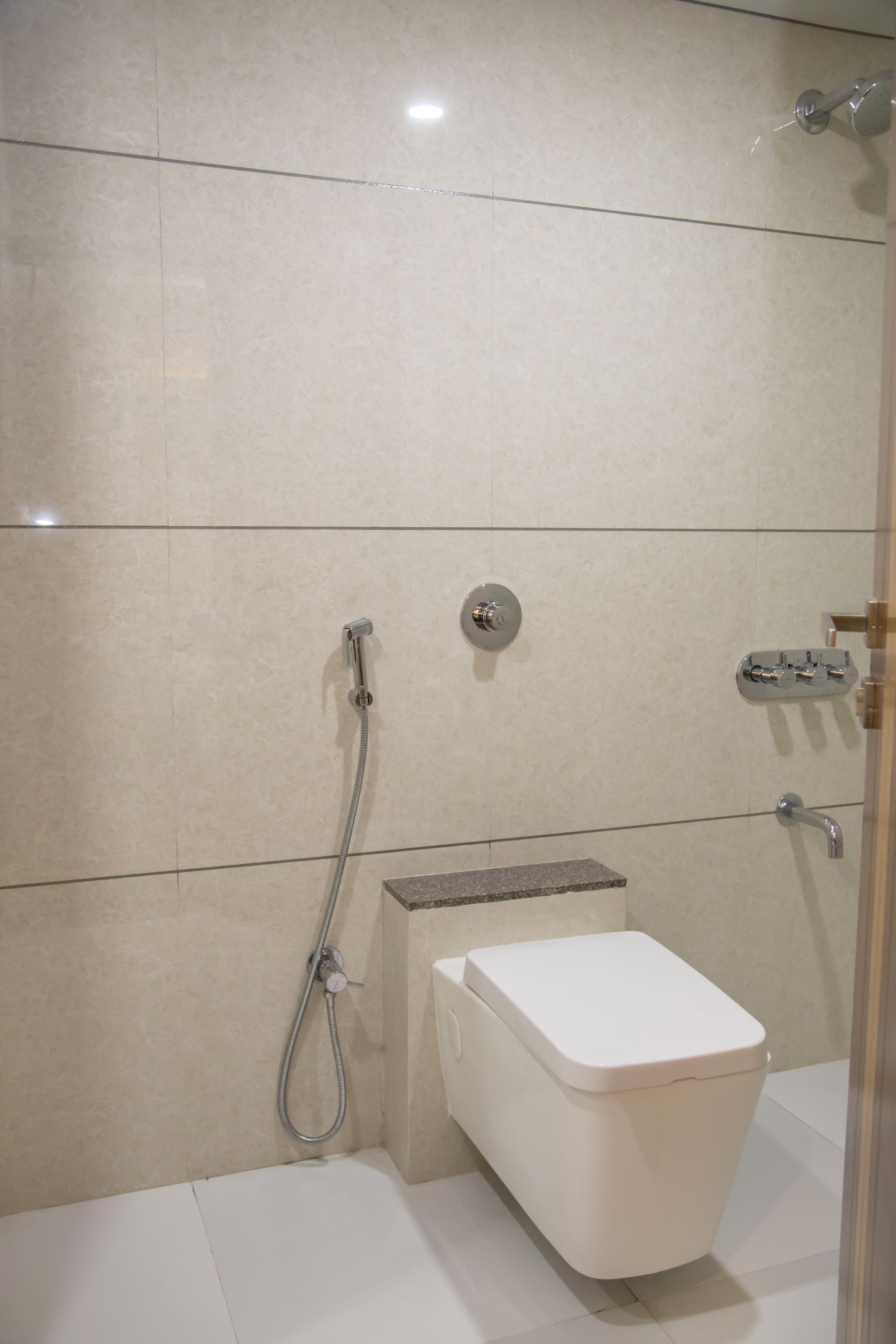A modern bathroom with a toilet, a shower, and a sink.