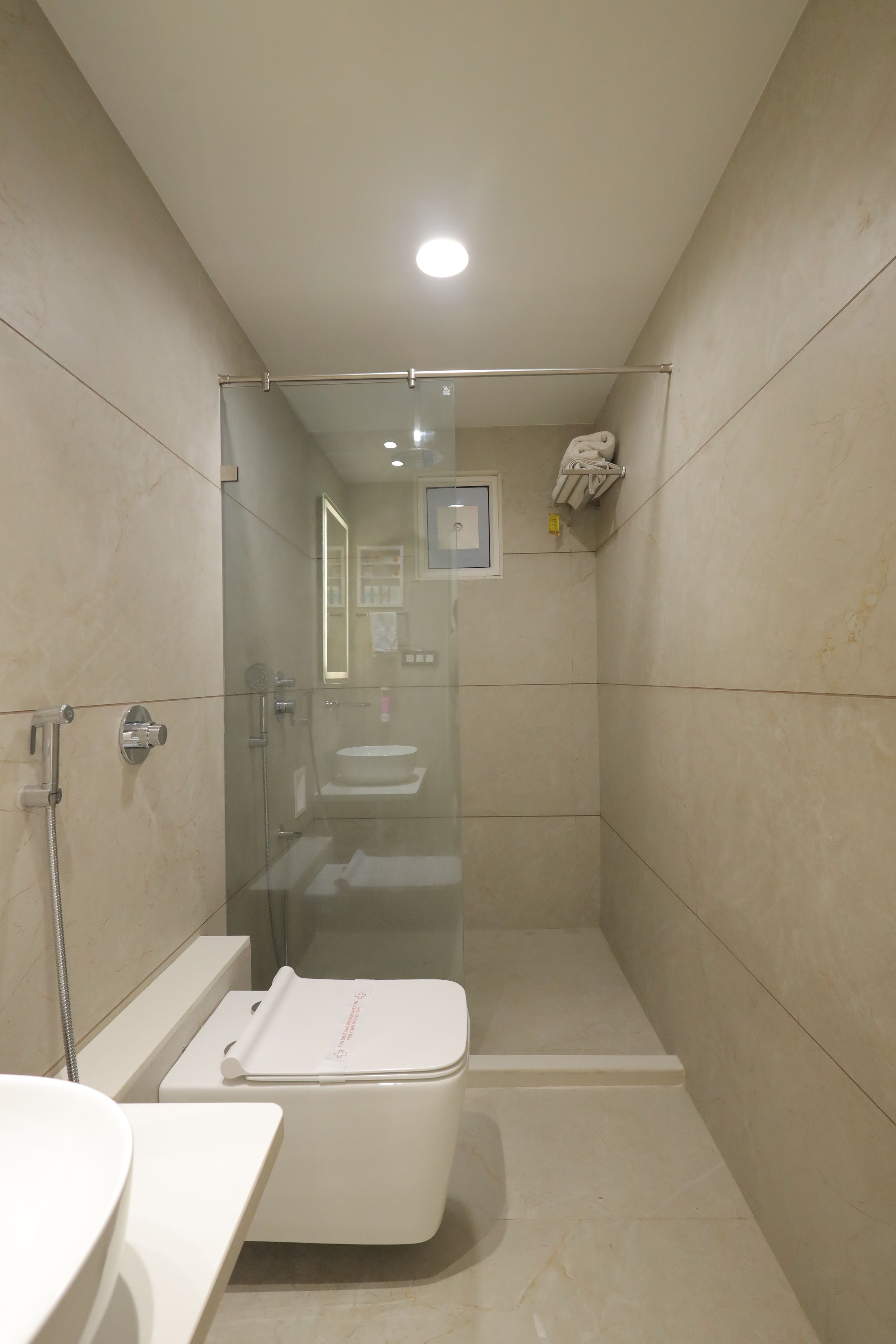 Une salle de bain moderne avec une douche à parois de verre, des toilettes blanches et un lavabo.