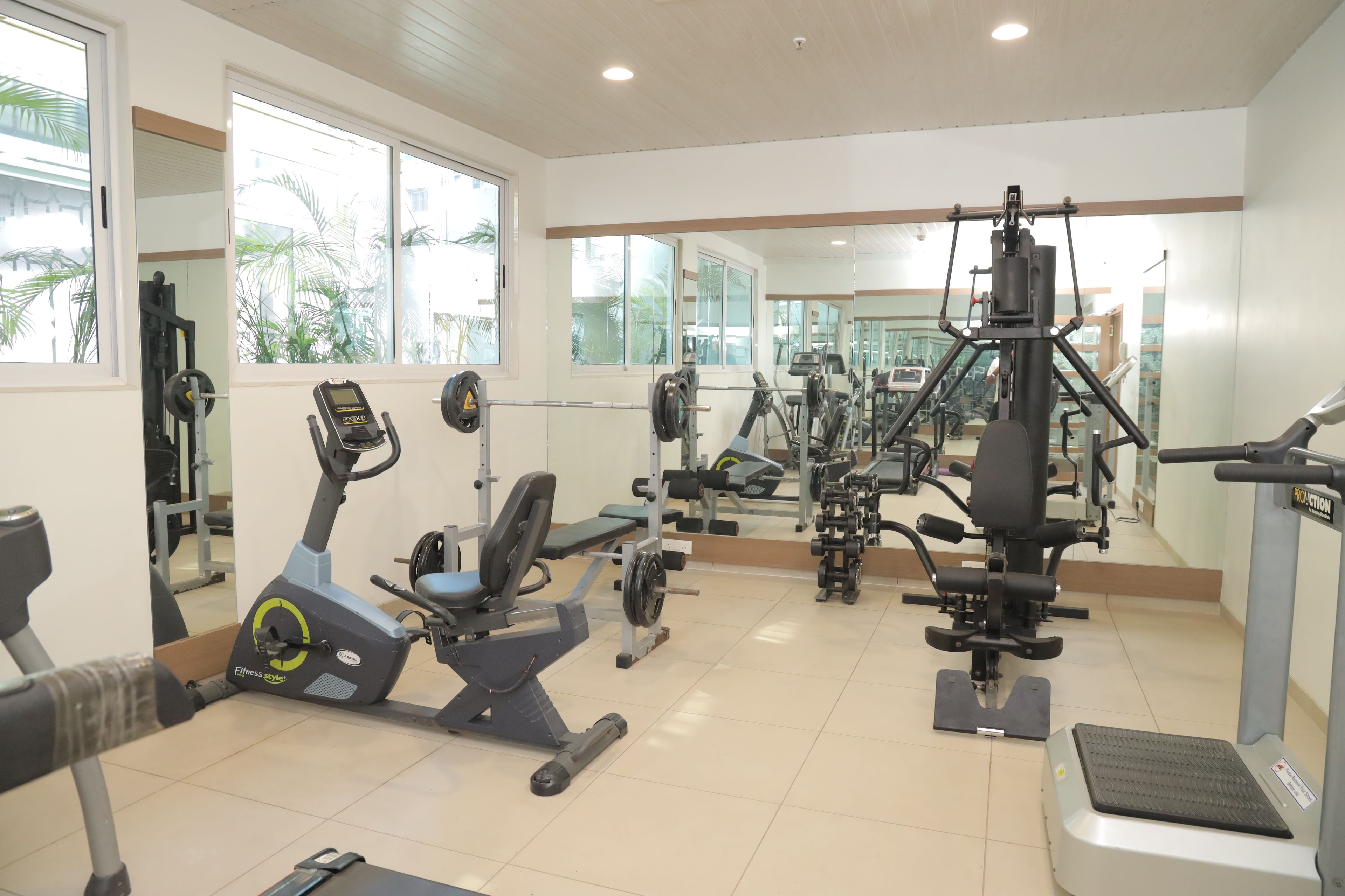 A gym with various exercise equipment, including treadmills, weight machines, and free weights.