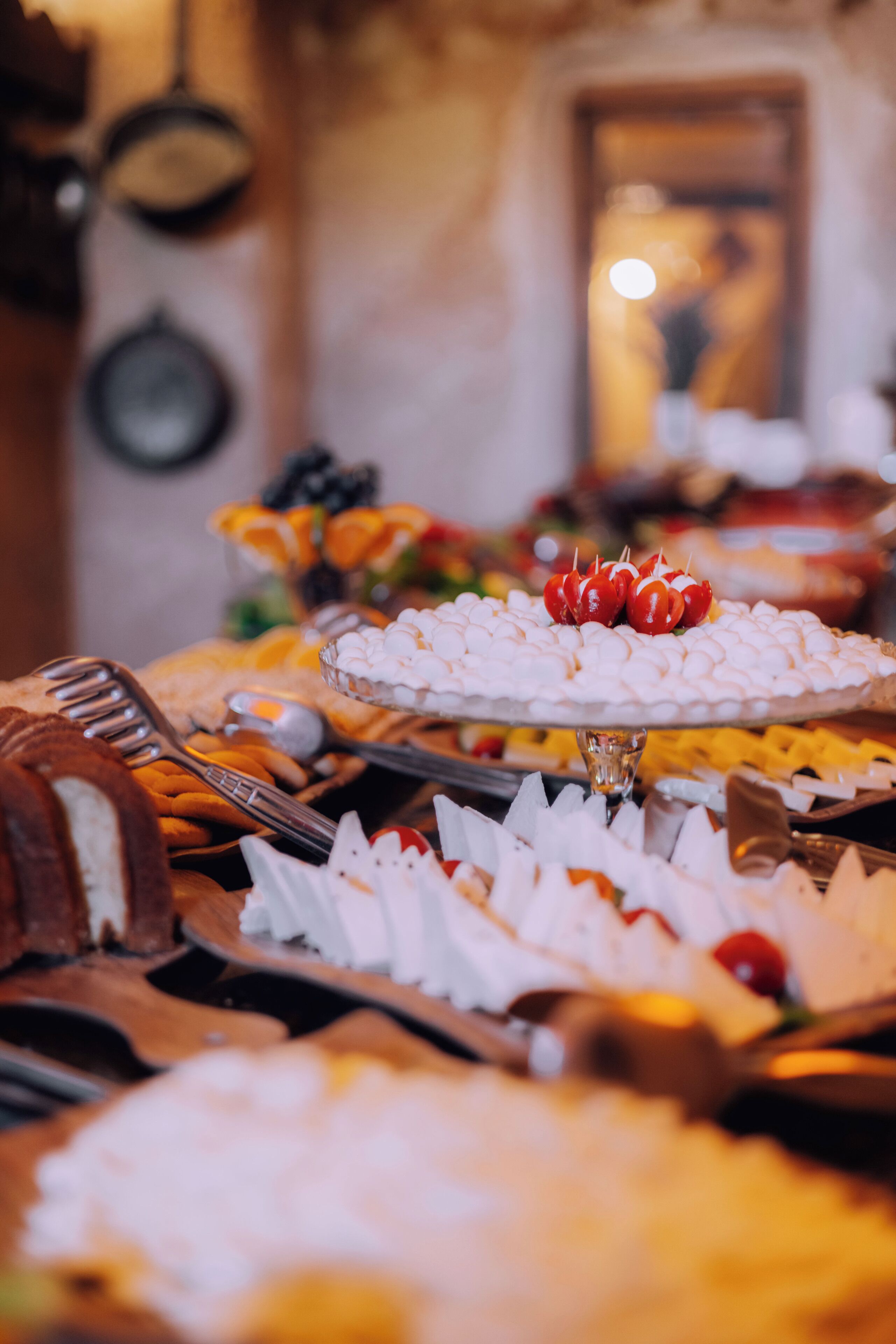 A buffet with various food items, including a cake and a tray of marshmallows.