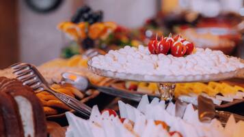 A buffet with various food items, including a cake and a tray of marshmallows.