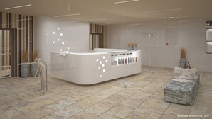 A modern reception area with a white reception desk, a clock, and a digital display. - VacationClub - Baltic Park Molo Apartments (Swinoujscie)