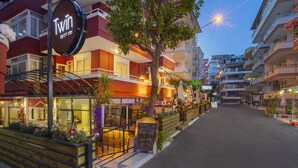 A Twin apartment building with a signboard advertising a special beef steak and glass wine. - Twin Apart Hotel (Alanya)