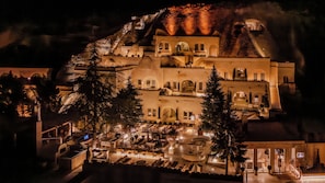A multi-story building with a courtyard, outdoor seating, and a staircase leading to the upper levels. - Avantgarde Refined Caves of Cappadocia, Member of Small Luxury Hotel of the World (Ürgüp)