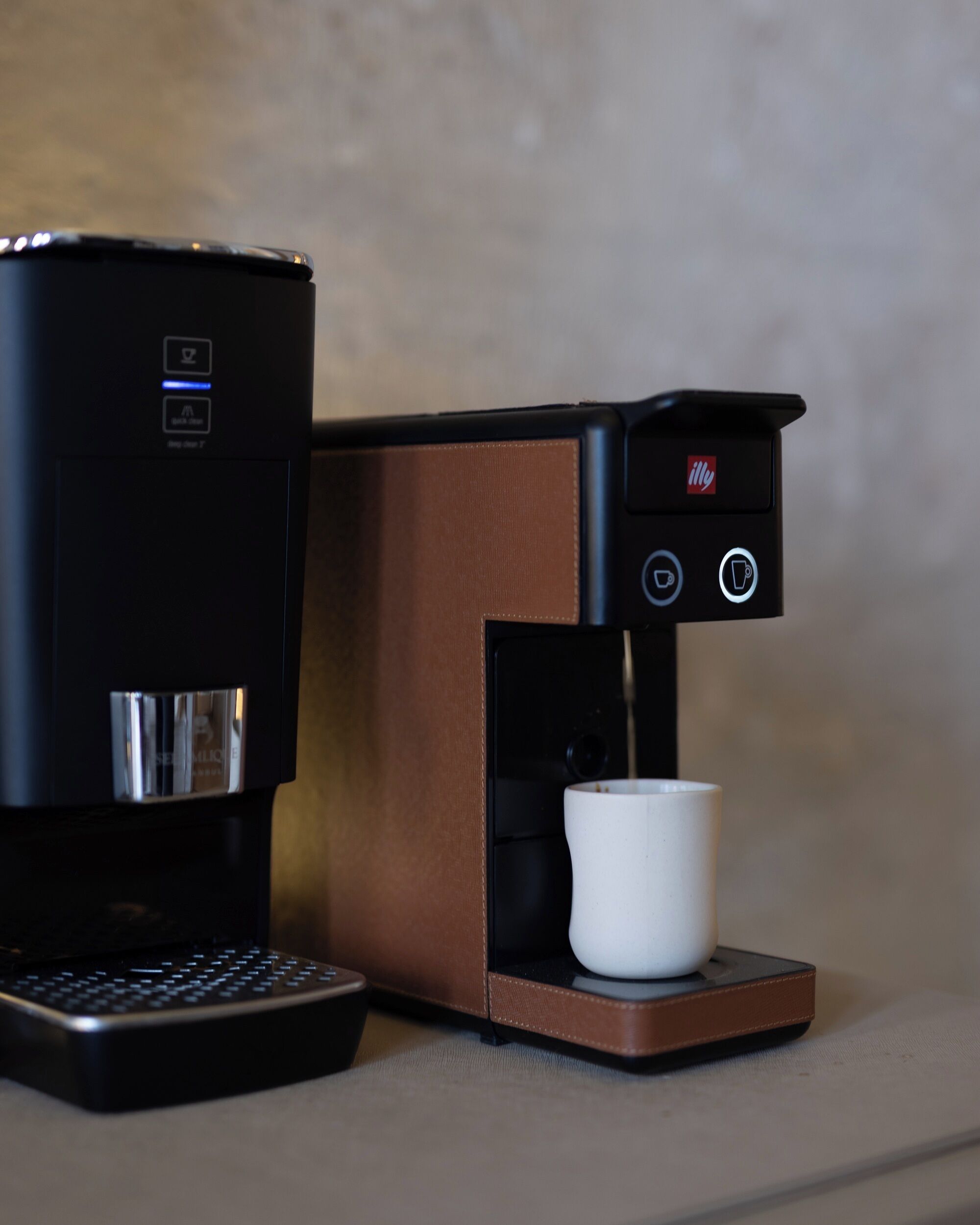 Una cafetera con un portavasos y un panel de control.