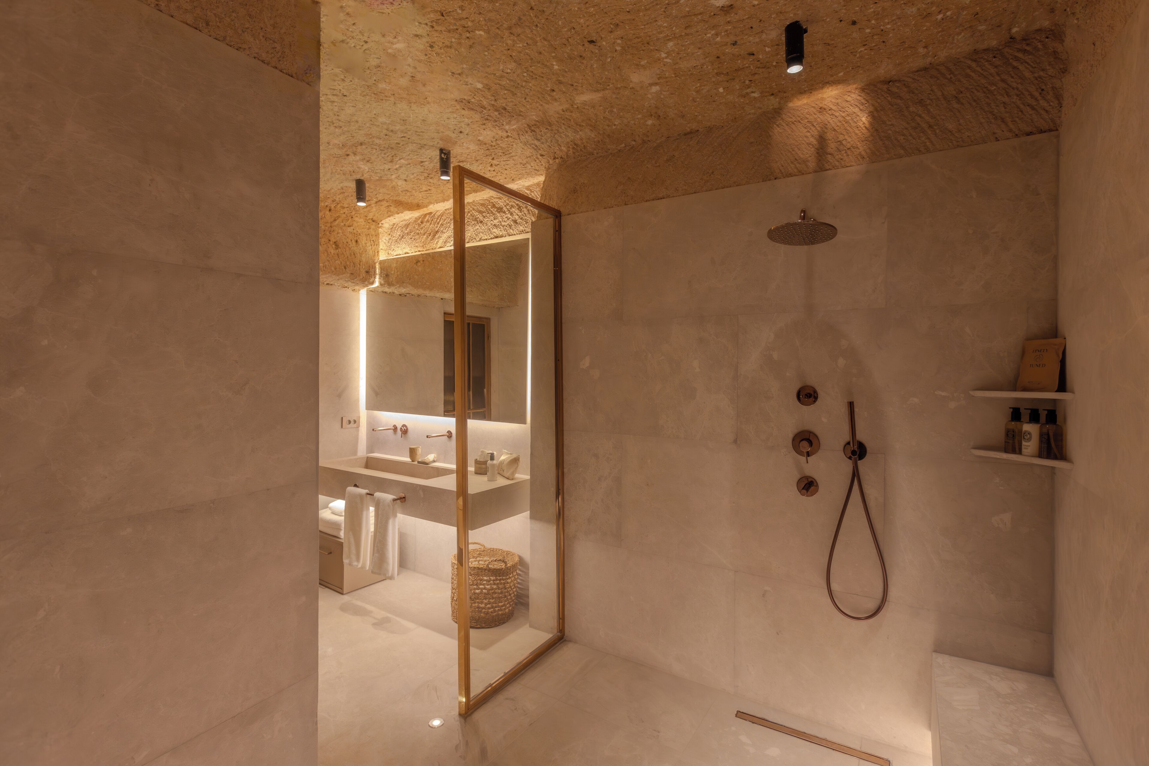 Une salle de bain moderne dotée d’une cabine de douche en verre, d’un grand miroir et d’un design minimaliste.