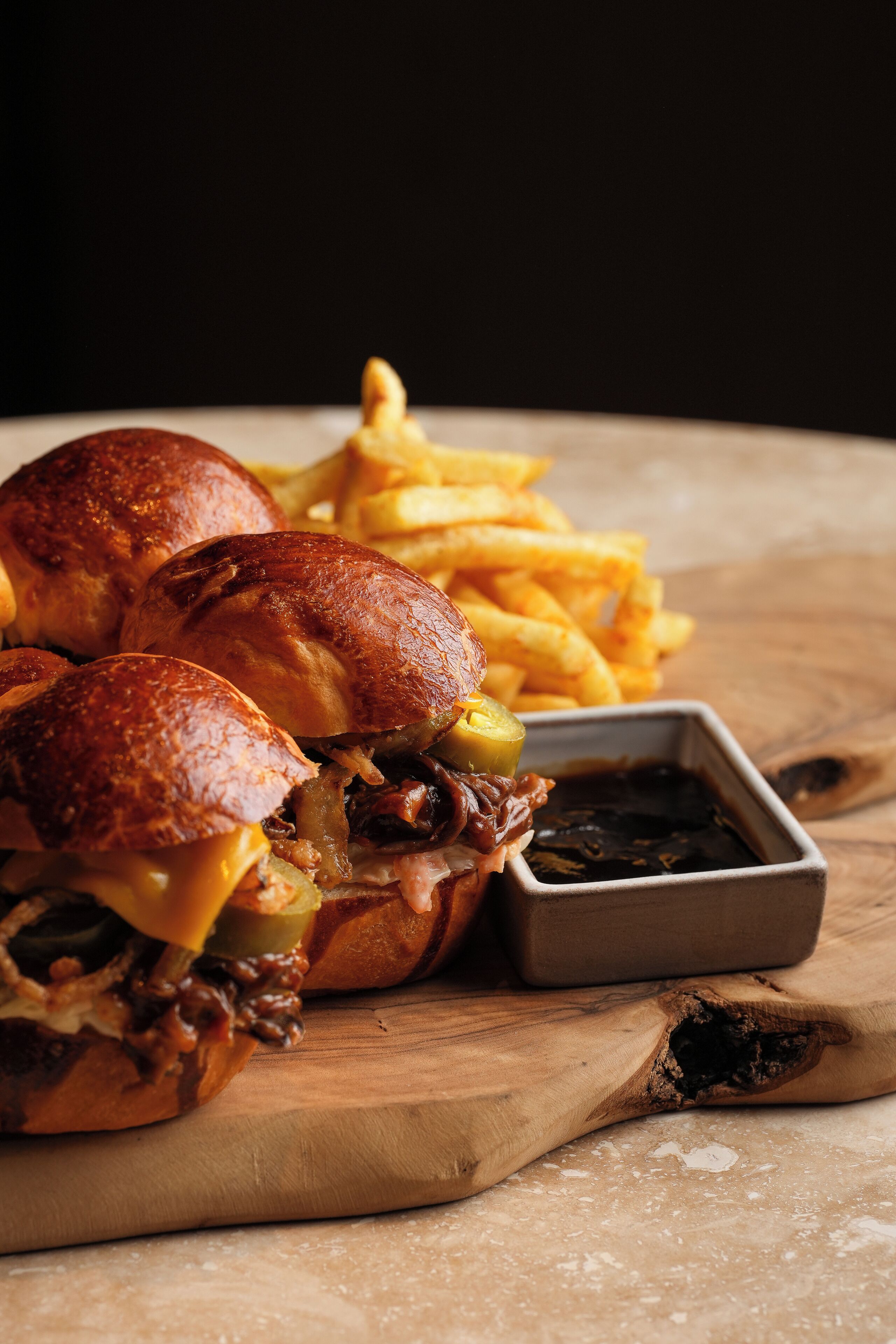 A sandwich and fries on a wooden board.