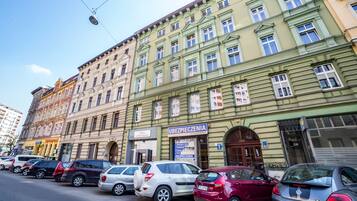 A row of parked cars in front of a building with a sign that reads "Ubezpieczenie".