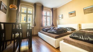 Una habitación con cama, escritorio y ventana con cortinas.