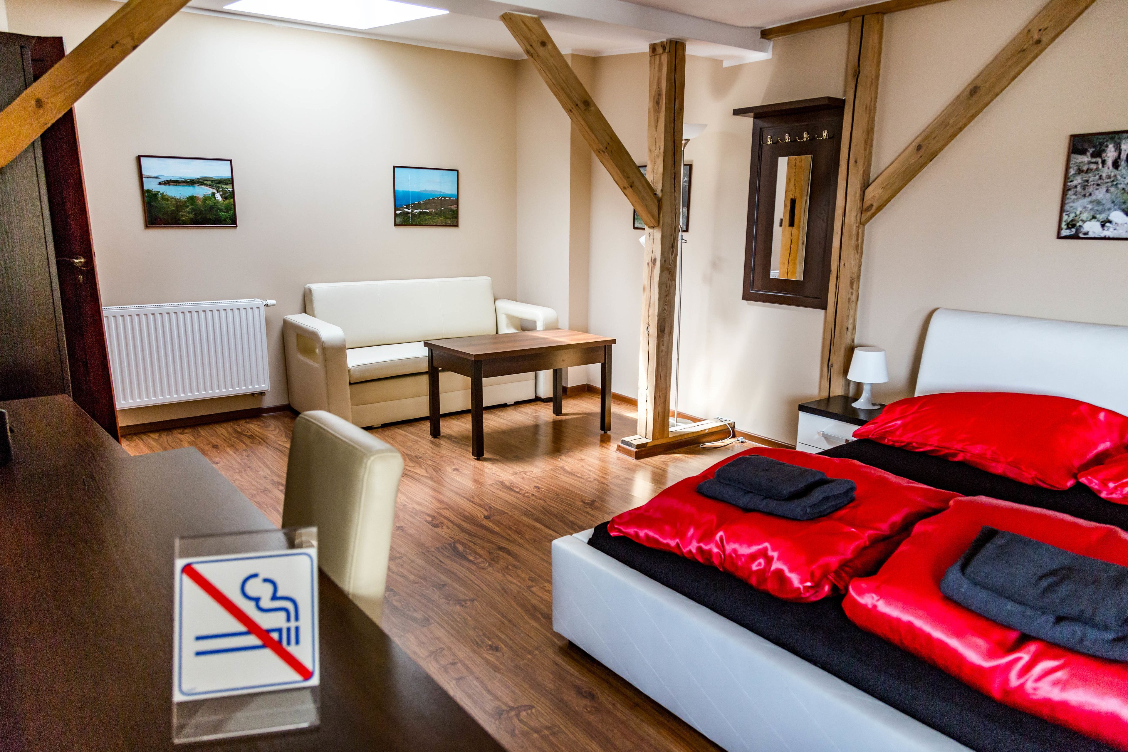 Habitación de hotel con cama, escritorio, silla, sofá y vistas al exterior.
